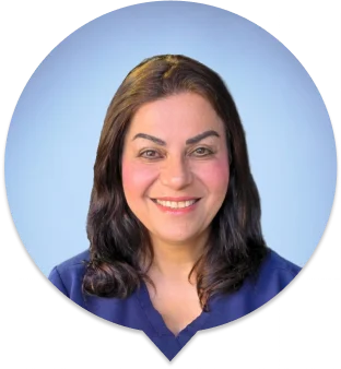 Dr. Bagheri DDS dentist smiling in navy dental scrubs against blue gradient background